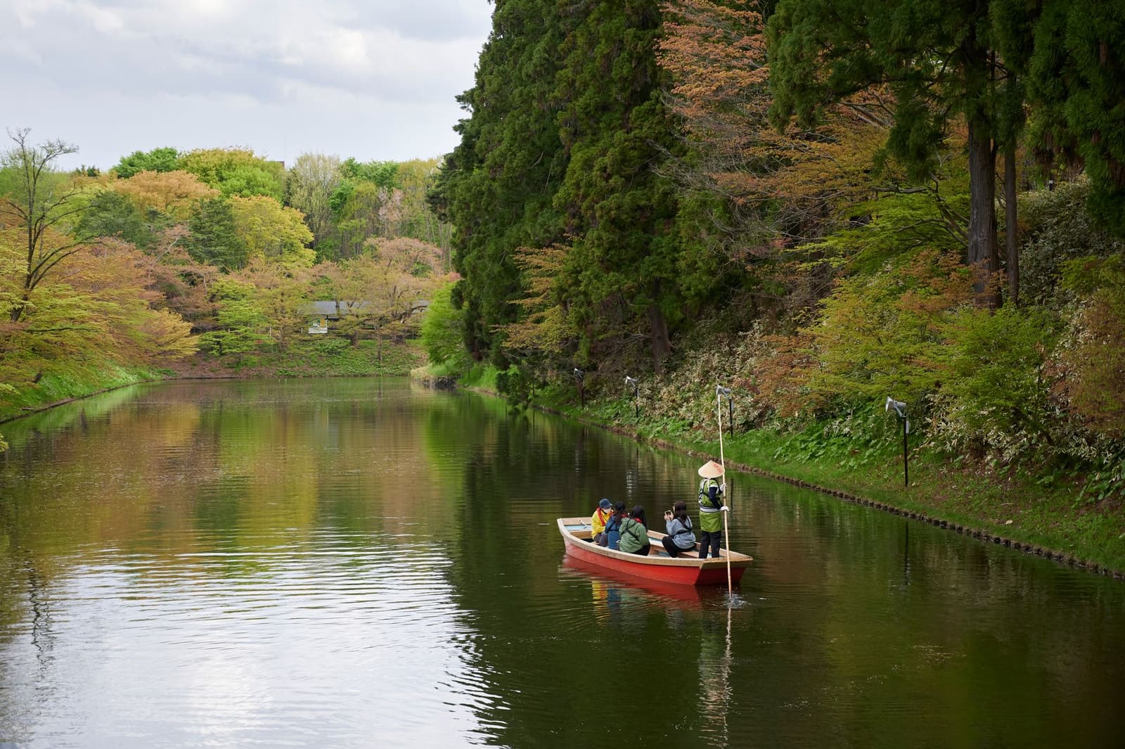 Rowing boat on a calm tree-lined waterway at Hirosaki in Aomori prefecture