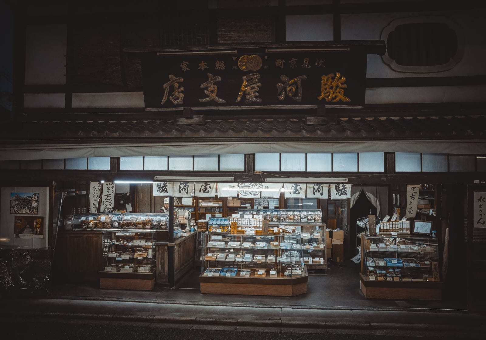 Traditional wooden shopfront with goods laid out under a tiled roof at Kawagoe