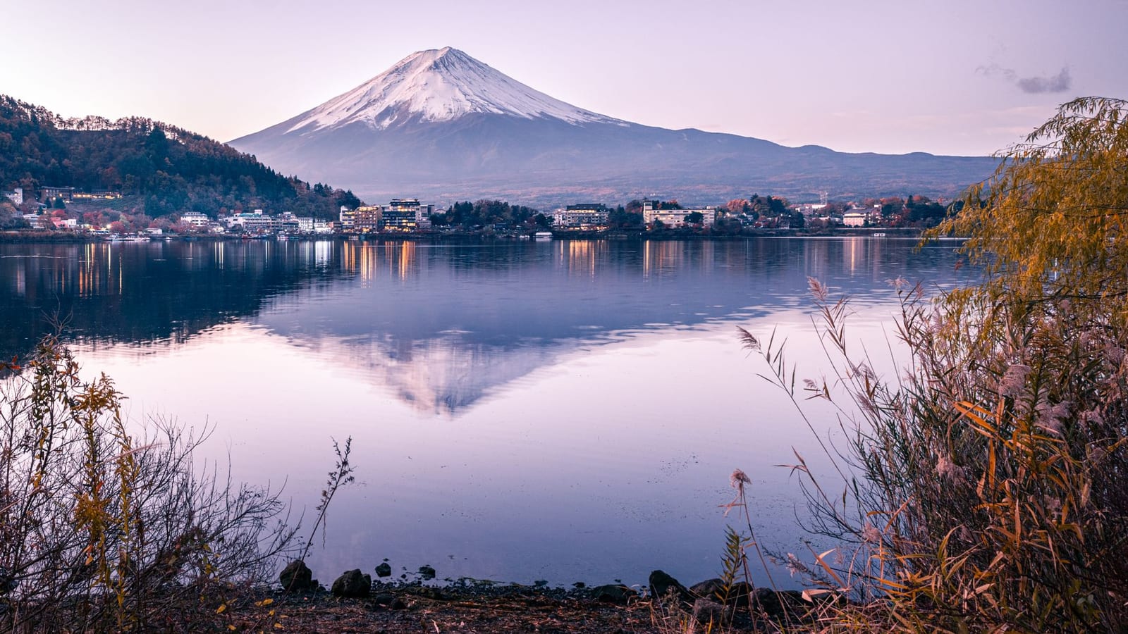 Mount Fuji reflected in the still water of Lake Kawaguchiko at dawn