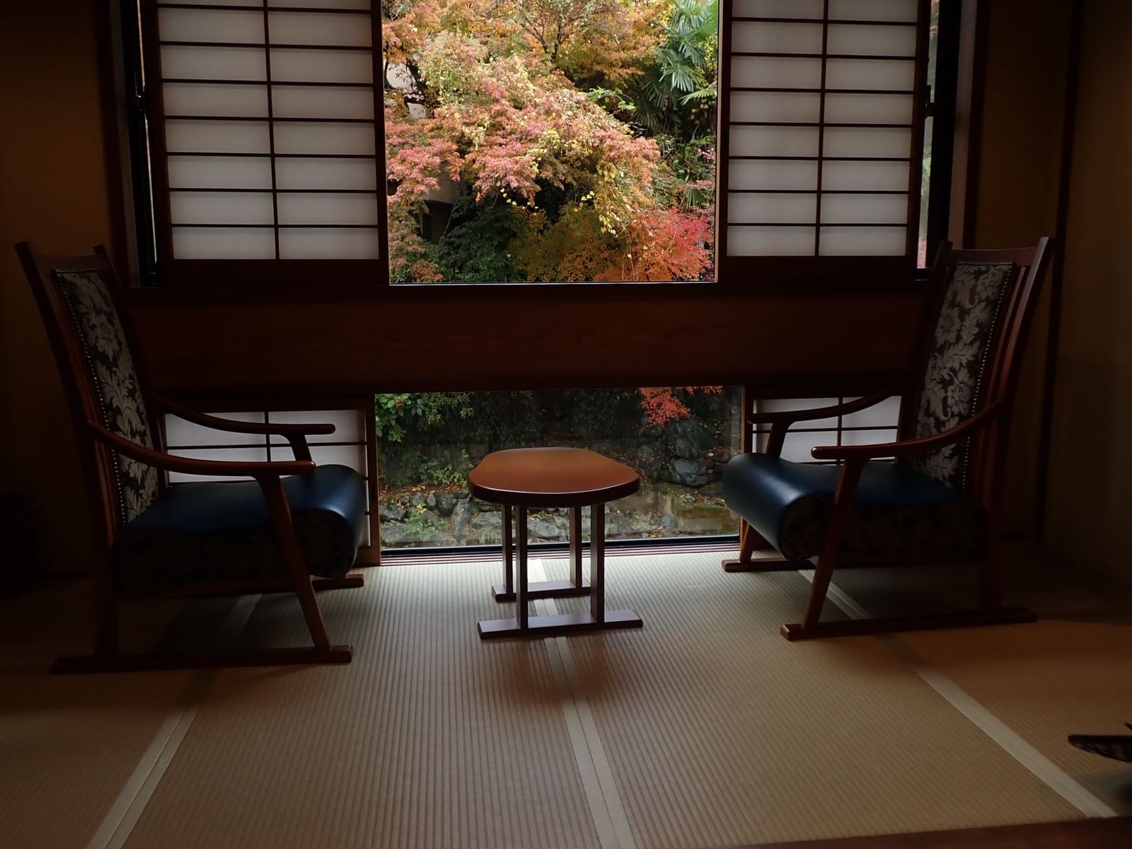 Tatami guest room in a traditional Japanese ryokan with a low table and garden view