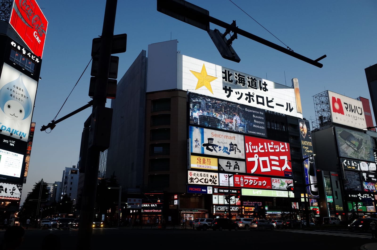 Illuminated billboards and street signage in central Sapporo at twilight
