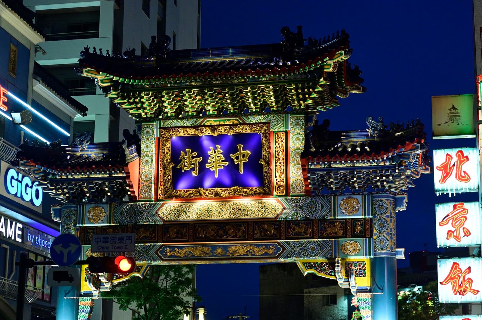 Illuminated ornate gate at the entrance to Yokohama's Chinatown at dusk
